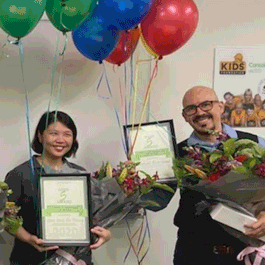 Staff awards - two staff members holding baloons and certificates